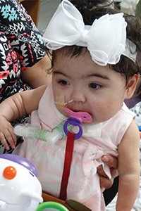 Girl with bow in her hair using a pacifier